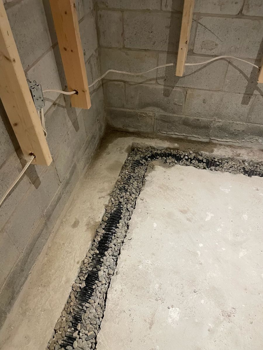 Trench cut along a block foundation wall for interior drainage tile
