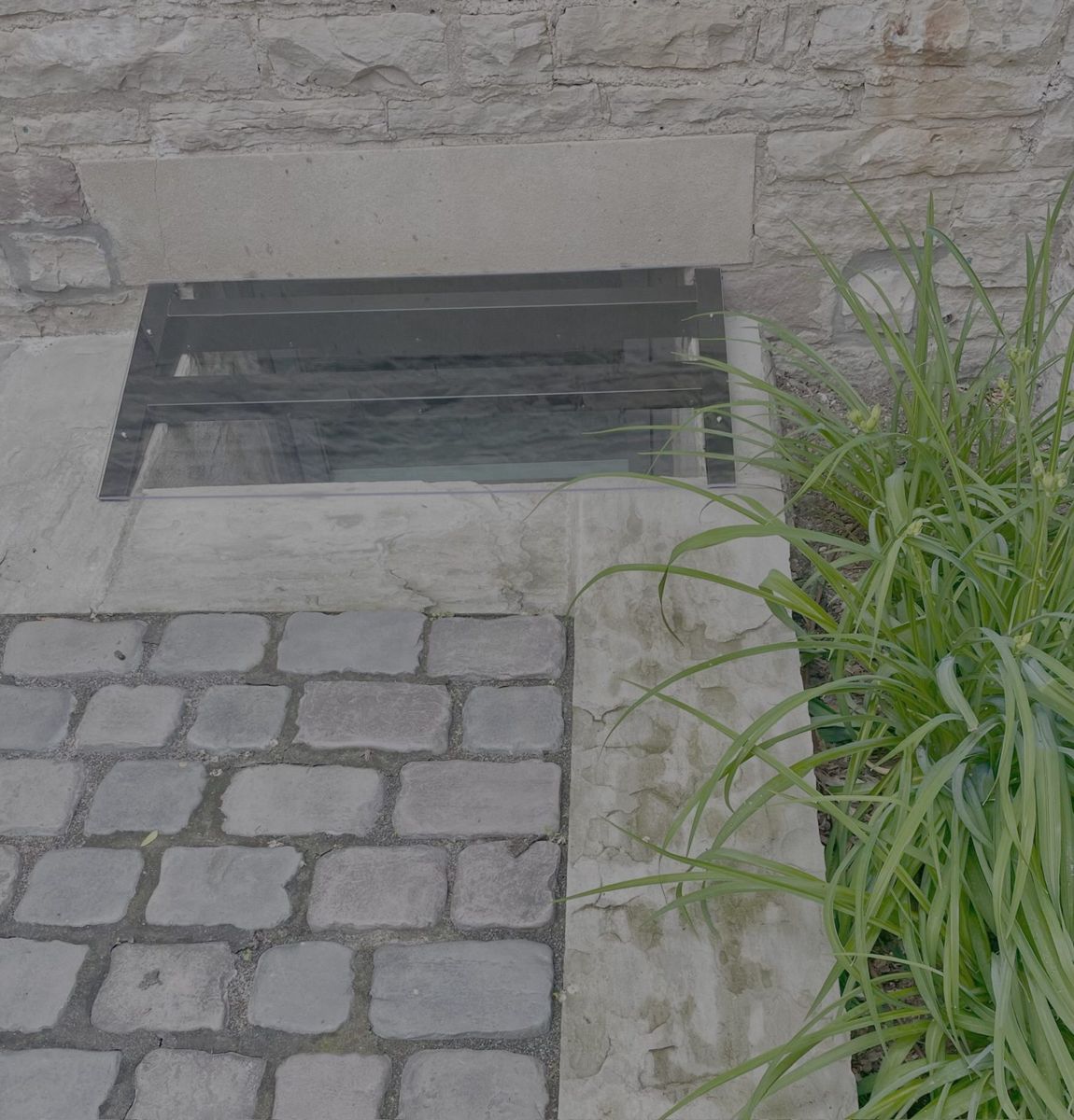 Flat window well cover set into a walkway